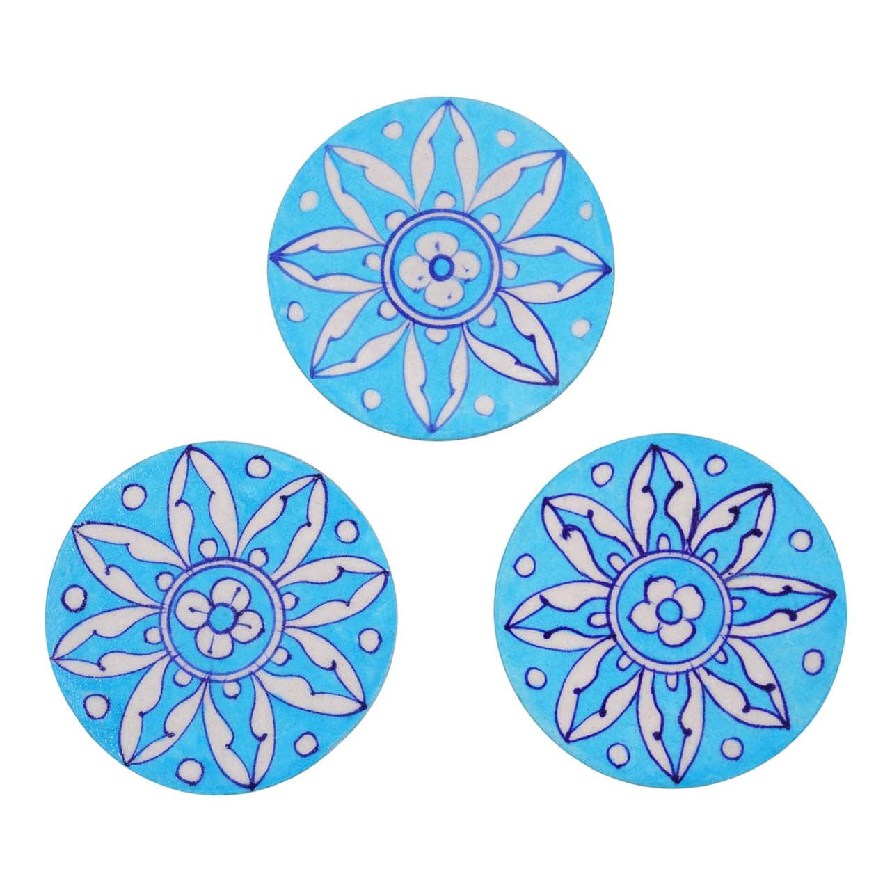 Three round ceramic coasters with blue floral patterns, set against a white background.