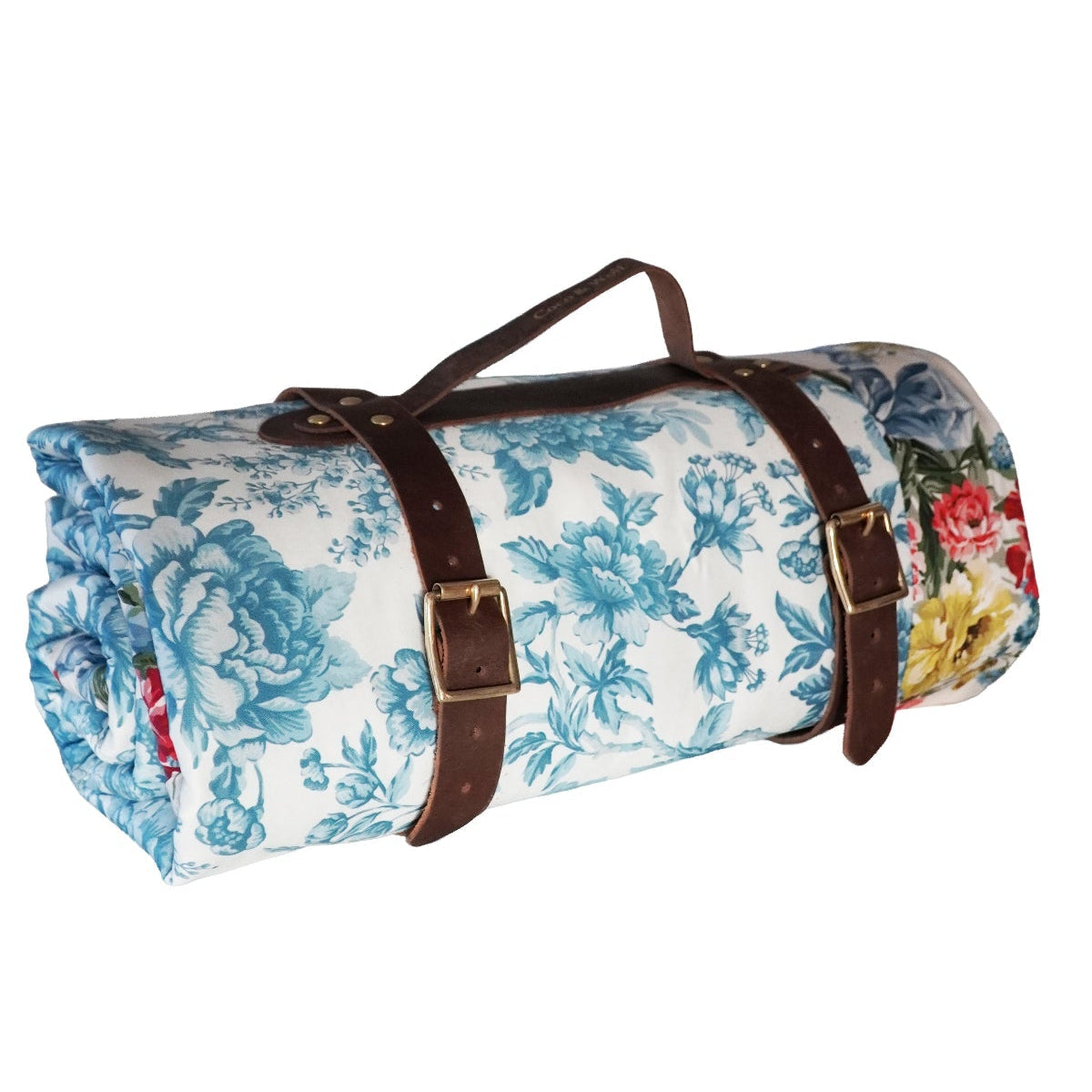 Floral-patterned roll-up rug with brown straps on a white background