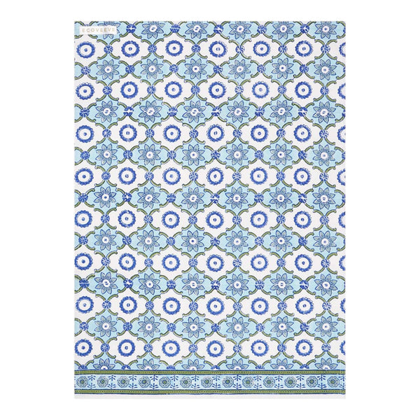 A folded handcrafted cotton tea towel with a geometric pattern in blue and white.