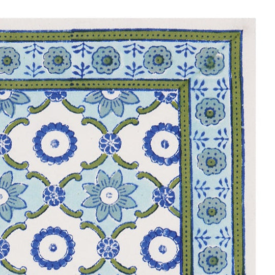 A rectangular cotton table mat with a hand-block printed geometric pattern in blue and green hues.