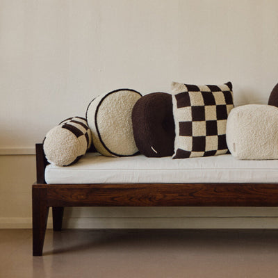 Cream wool bouclé round piped cushion on daybed - handmade in UK