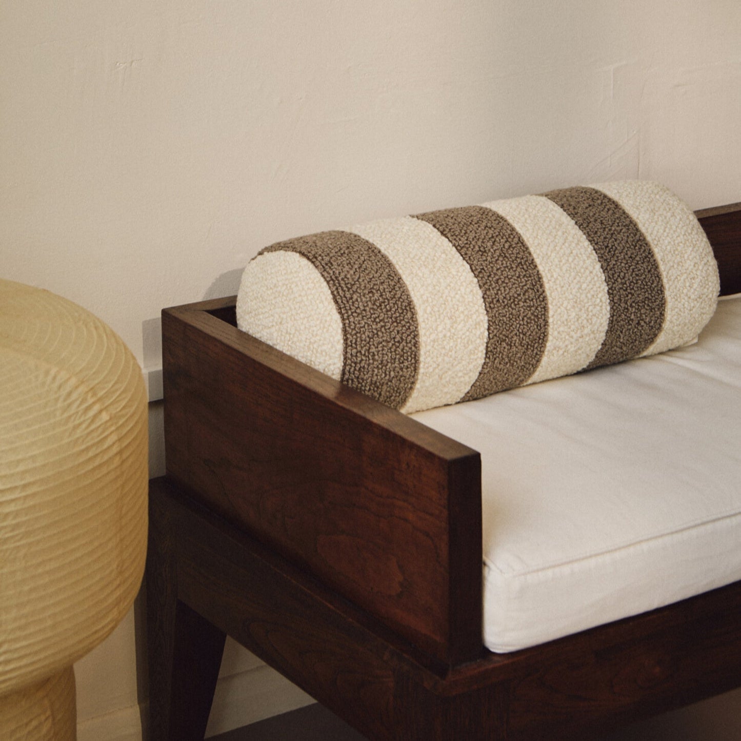 Lifestyle closeup of cream and beige wool bouclé striped bolster cushion