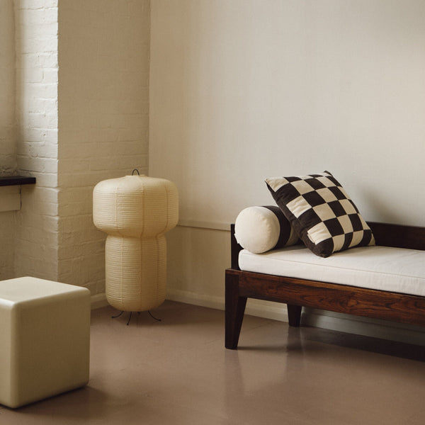 Lifestyle shot of cream and brown cotton corduroy checkered square cushion on daybed