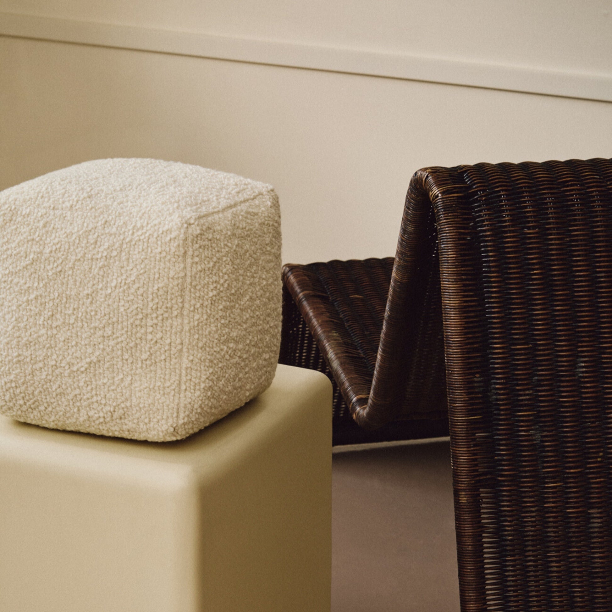 Lifestyle abstract shot of cream wool bouclé cube cushion on plinth
