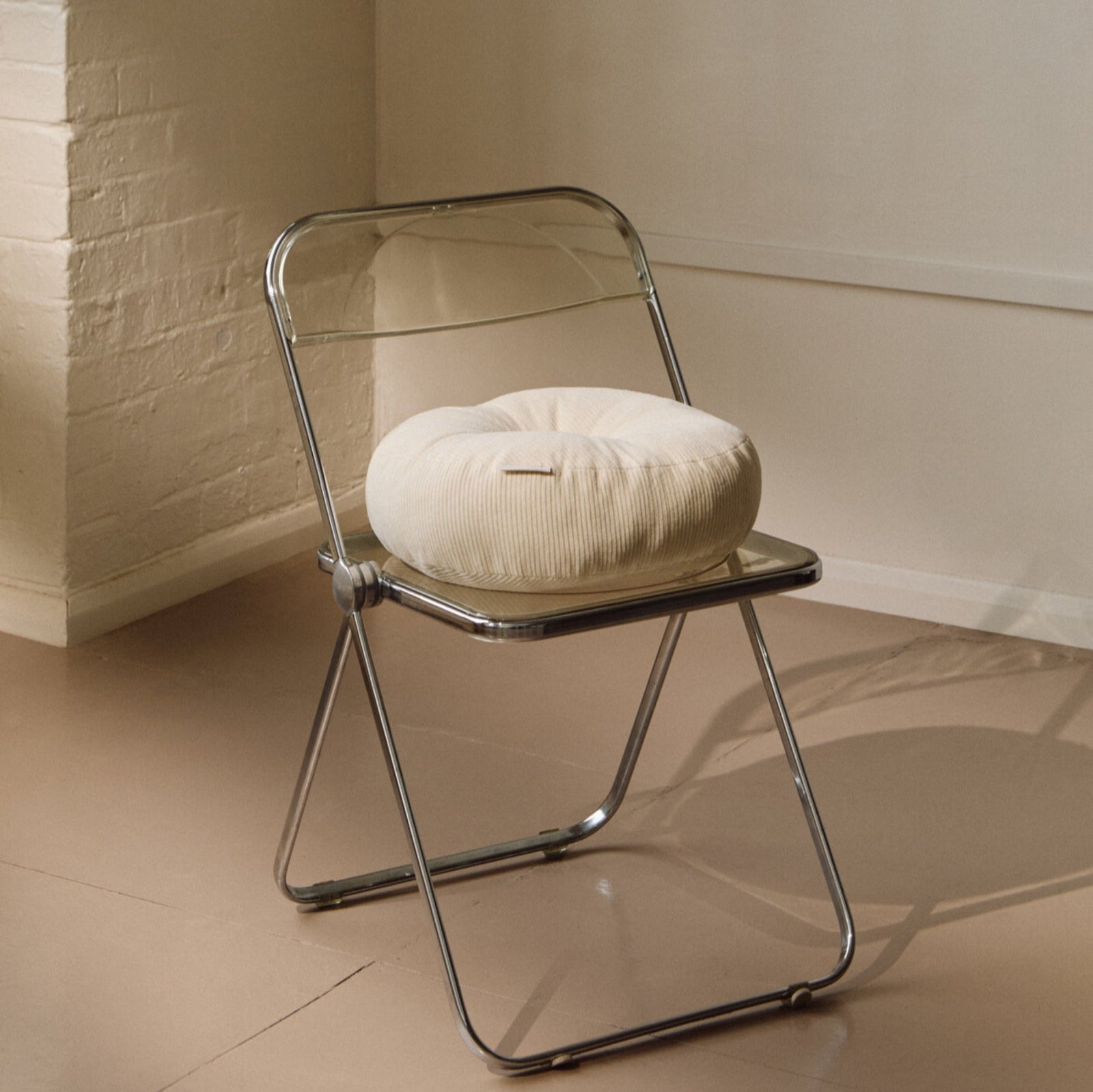 Lifestyle shot of cream cotton corduroy round cushion on chair