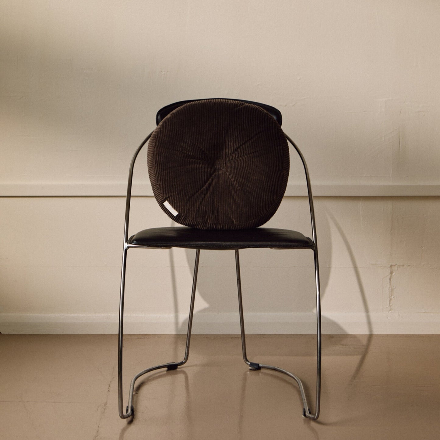 Lifestyle shot of brown cotton corduroy round cushion on chair