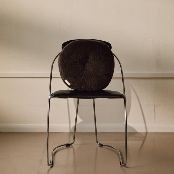 Lifestyle shot of brown cotton corduroy round cushion on chair