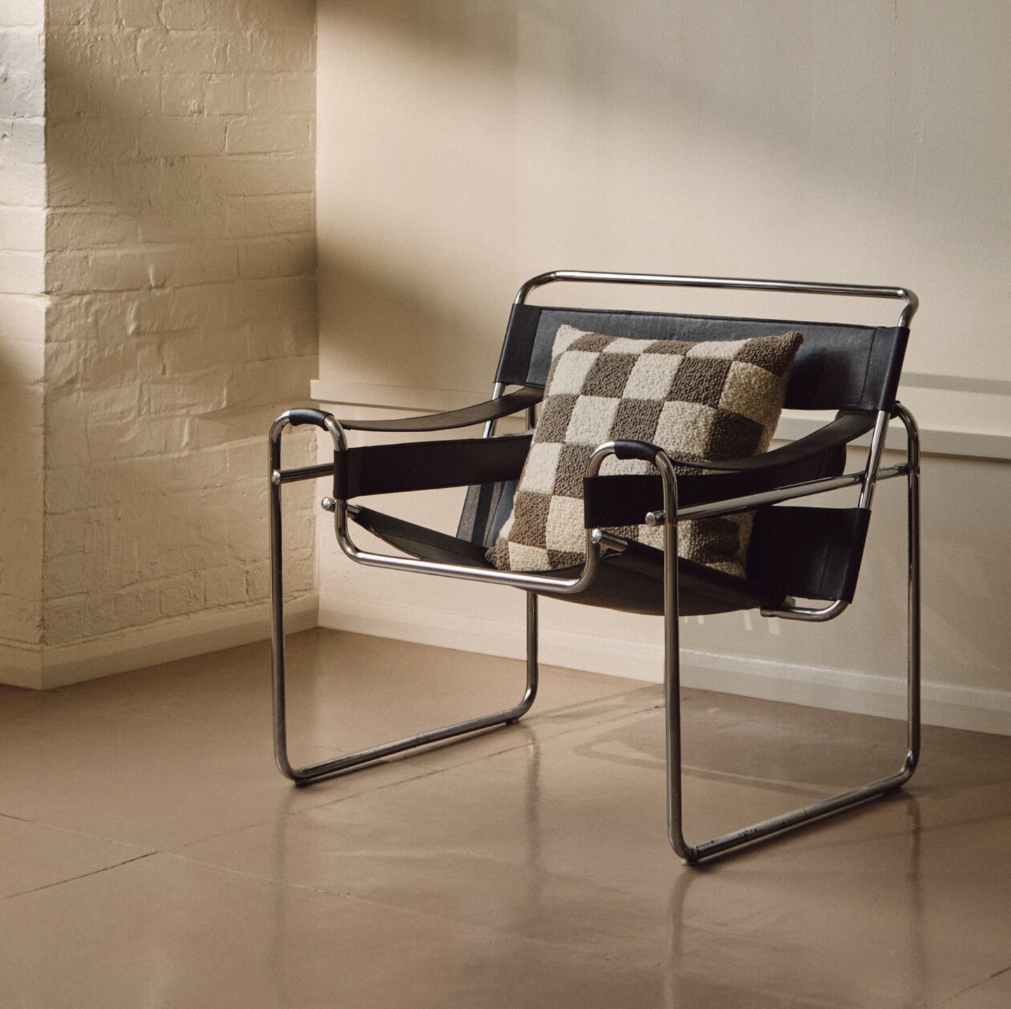 Lifestyle shot of cream and beige wool bouclé checkered square cushion on chair