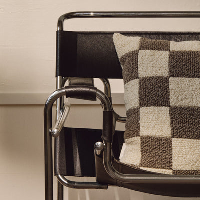 Lifestyle shot of cream and beige wool bouclé checkered square cushion on chair