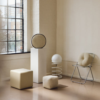 Cream wool bouclé round piped cushion on plinth - handmade in UK