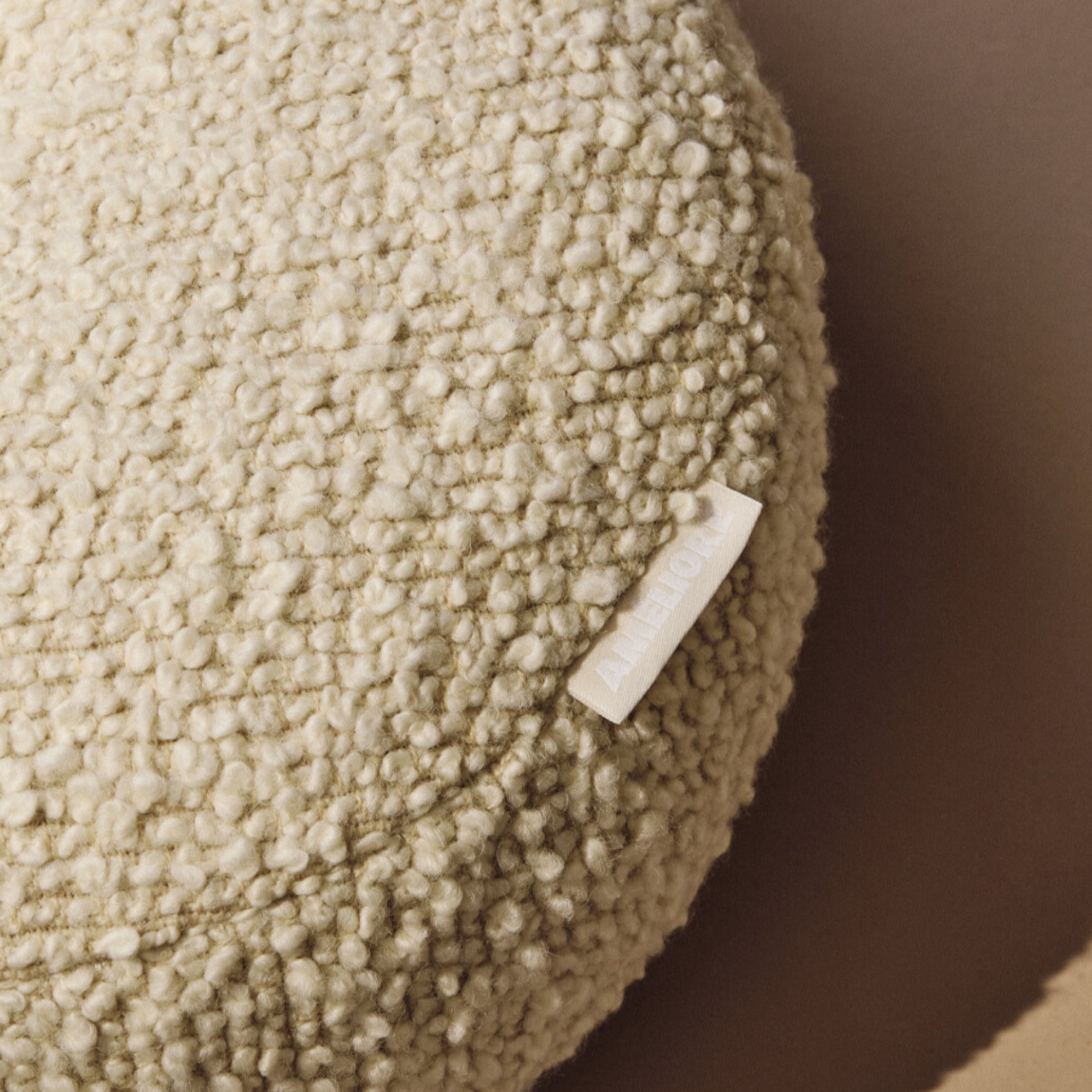 Lifestyle close up of cream wool bouclé round cushion