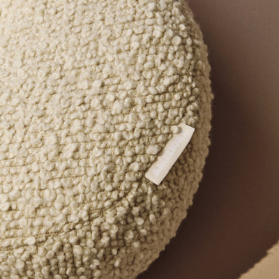 Lifestyle close up of cream wool bouclé round cushion