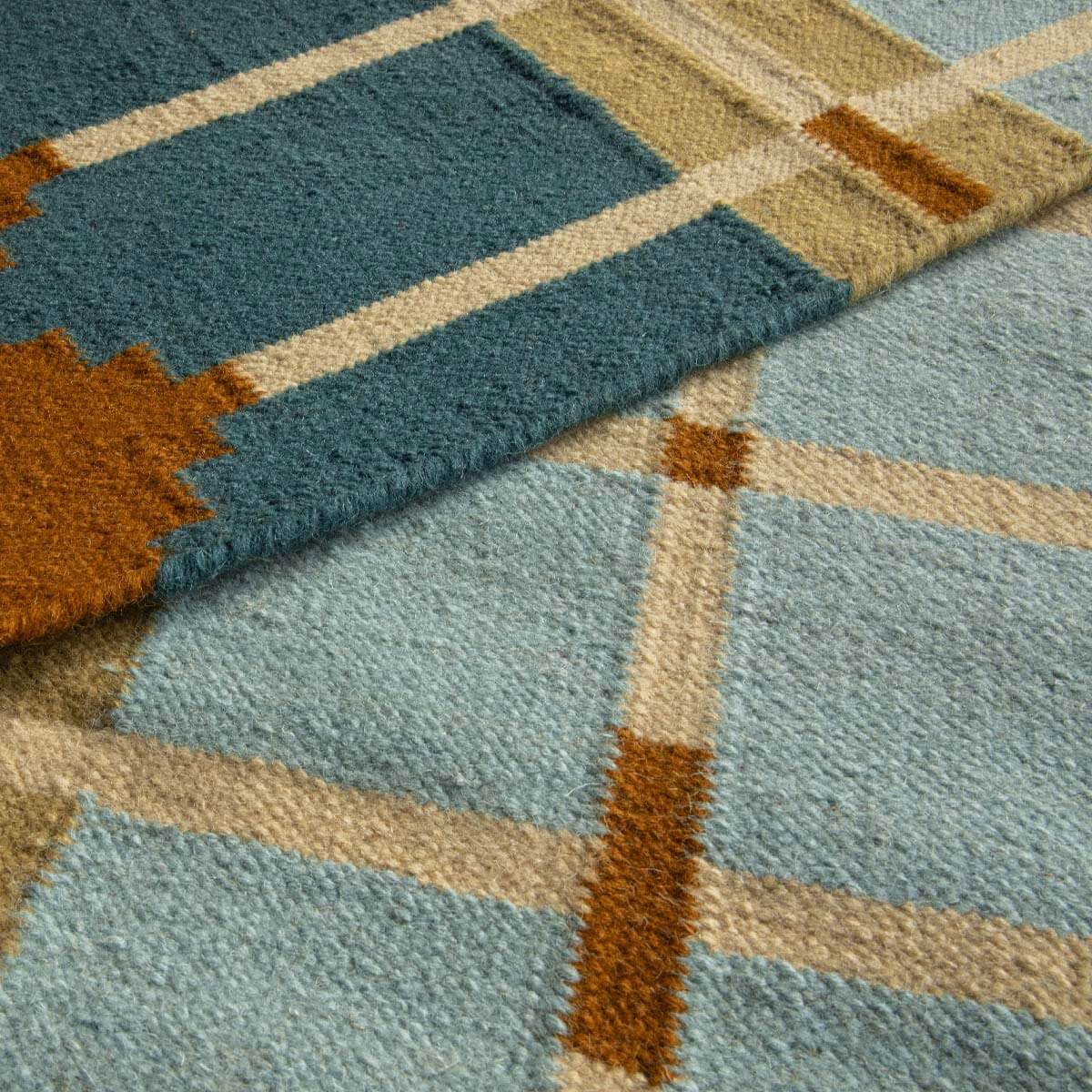 Close-up detail of Blue and Ochre Corbie handwoven wool rug showing grid design.