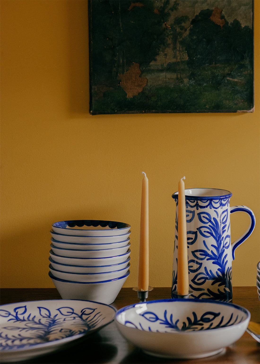Ceramic tableware with blue and white patterns on a yellow wall background
