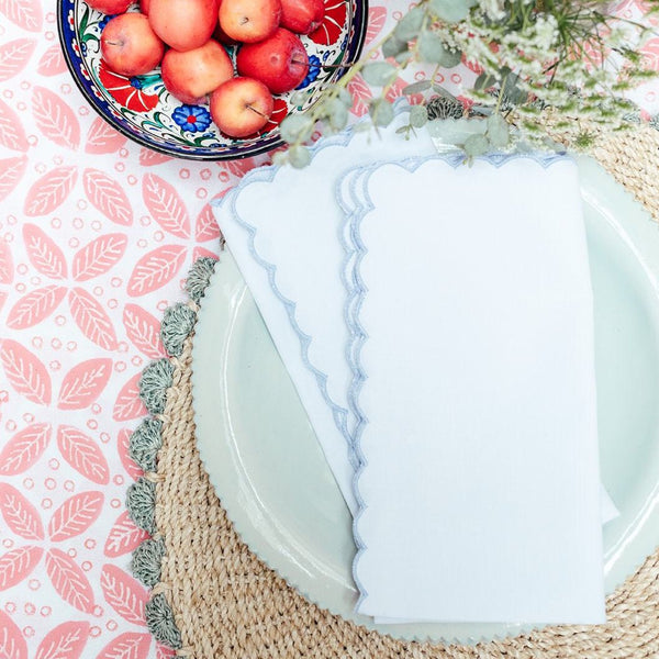 White napkin with blue scallop embroidered edge