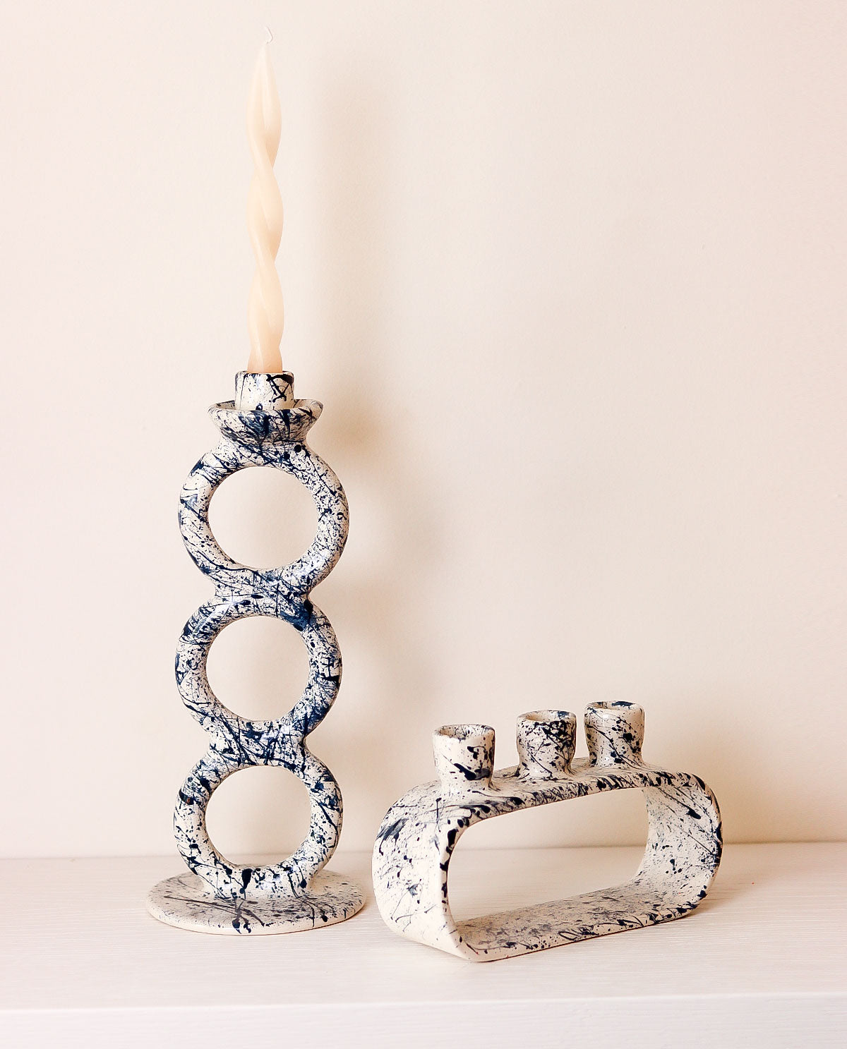 Decorative candle holders with marble-like pattern on a neutral background