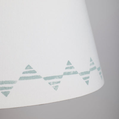 Close up of a cream lampshade with a blue triangle pattern – bold geometric empire lampshade in cream cotton, perfect for modern interiors.
