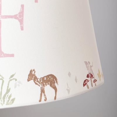 Close-up of woodland animals lampshade showing hand-printed deer, butterflies, fairies and mushrooms. A personalised lampshade for kids bedroom design, ideal as a christening gift and present for new parents.