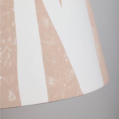 Close-up of cream lampshade with geometric triangle pattern in soft pink. This empire shade combines bold lampshade design with a neutral finish, ideal for modern and classic interiors.