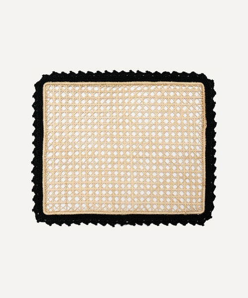 Nubia placemat in black, handwoven iraca palm, styled on a table