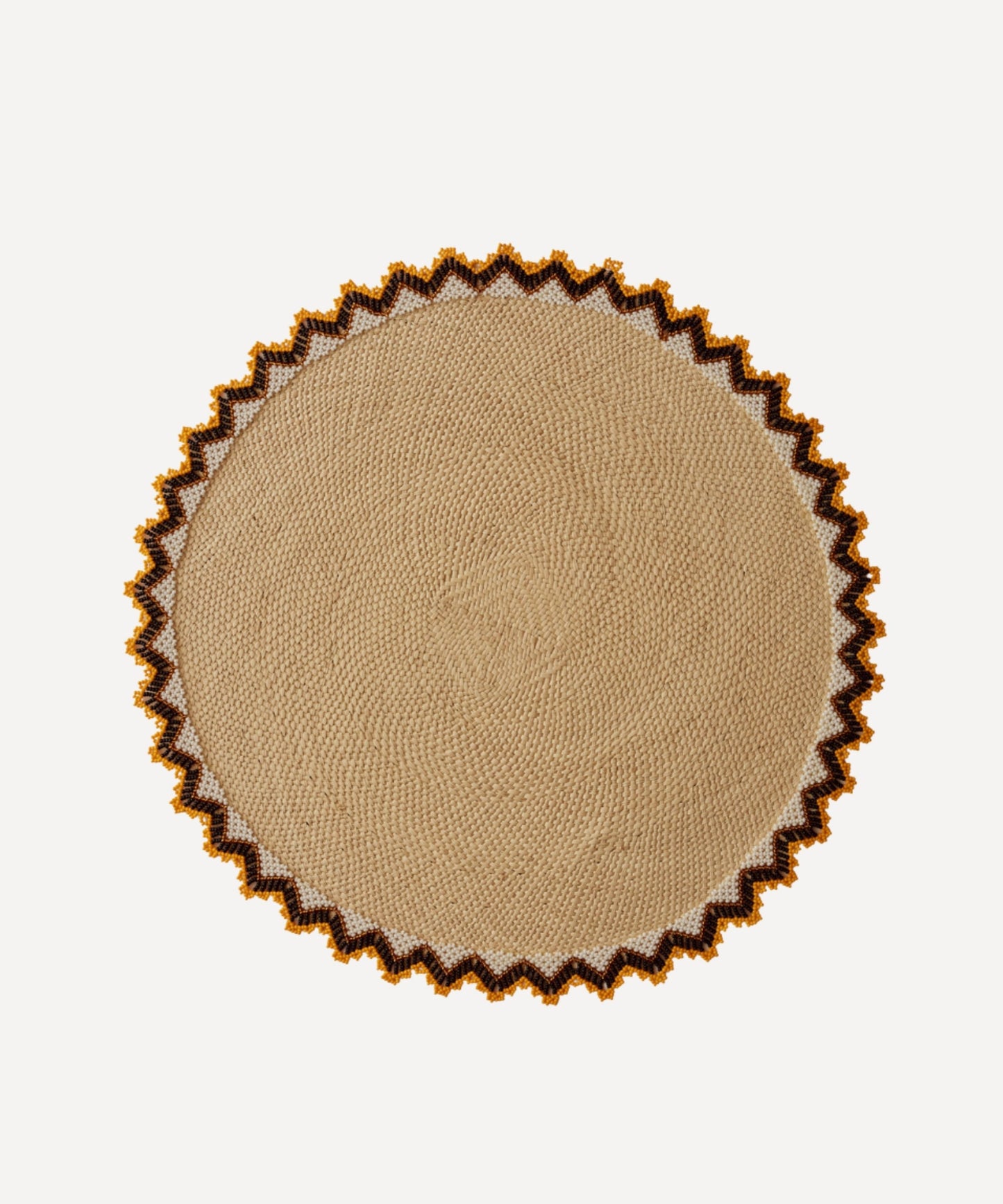 Alicia placemat in burnt yellow, handwoven iraca palm, styled on a table