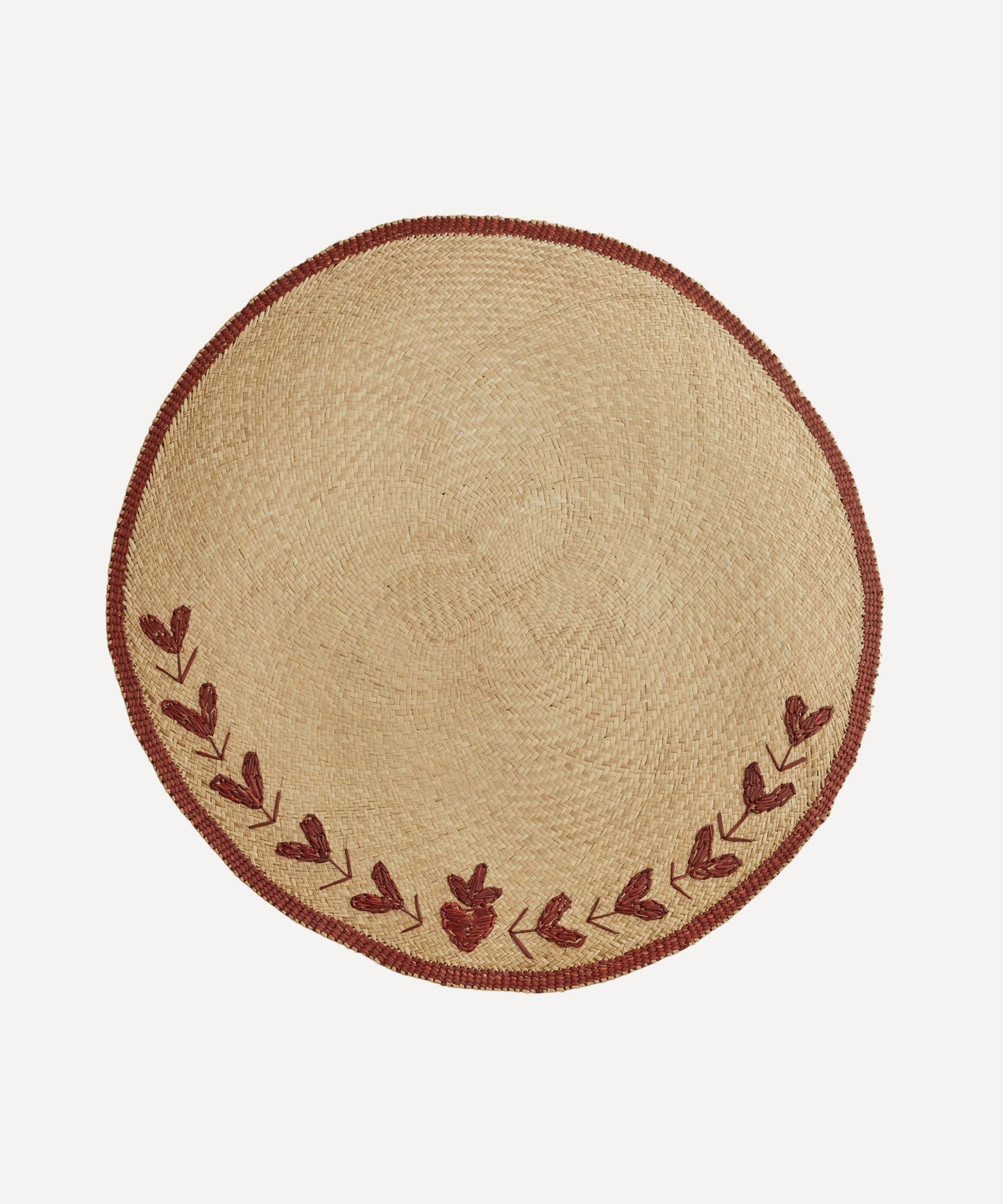 Corazon Nordic placemat, handwoven iraca palm with heart motif, on a table
