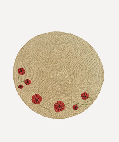 Poppy placemat, handwoven iraca palm with poppy motif, styled on a table