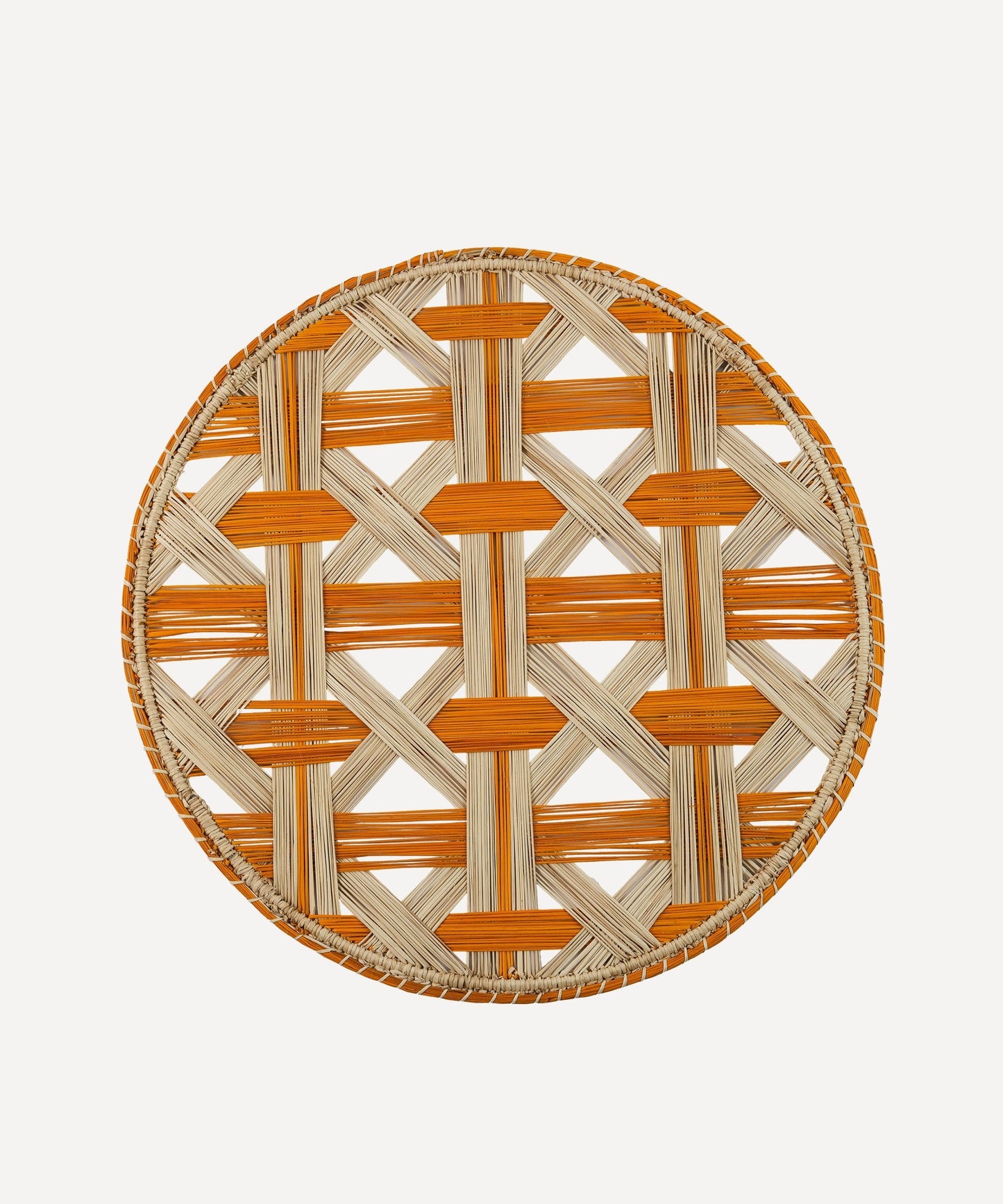 Atarraya net-weave placemat in mustard, handwoven iraca palm, on a table