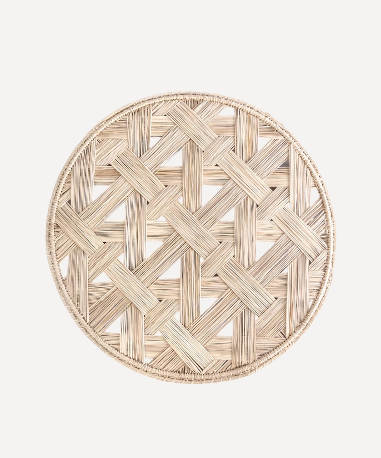Atarraya net-weave placemat in natural, handwoven iraca palm, on a table