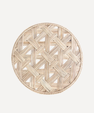 Atarraya net-weave placemat in natural, handwoven iraca palm, on a table