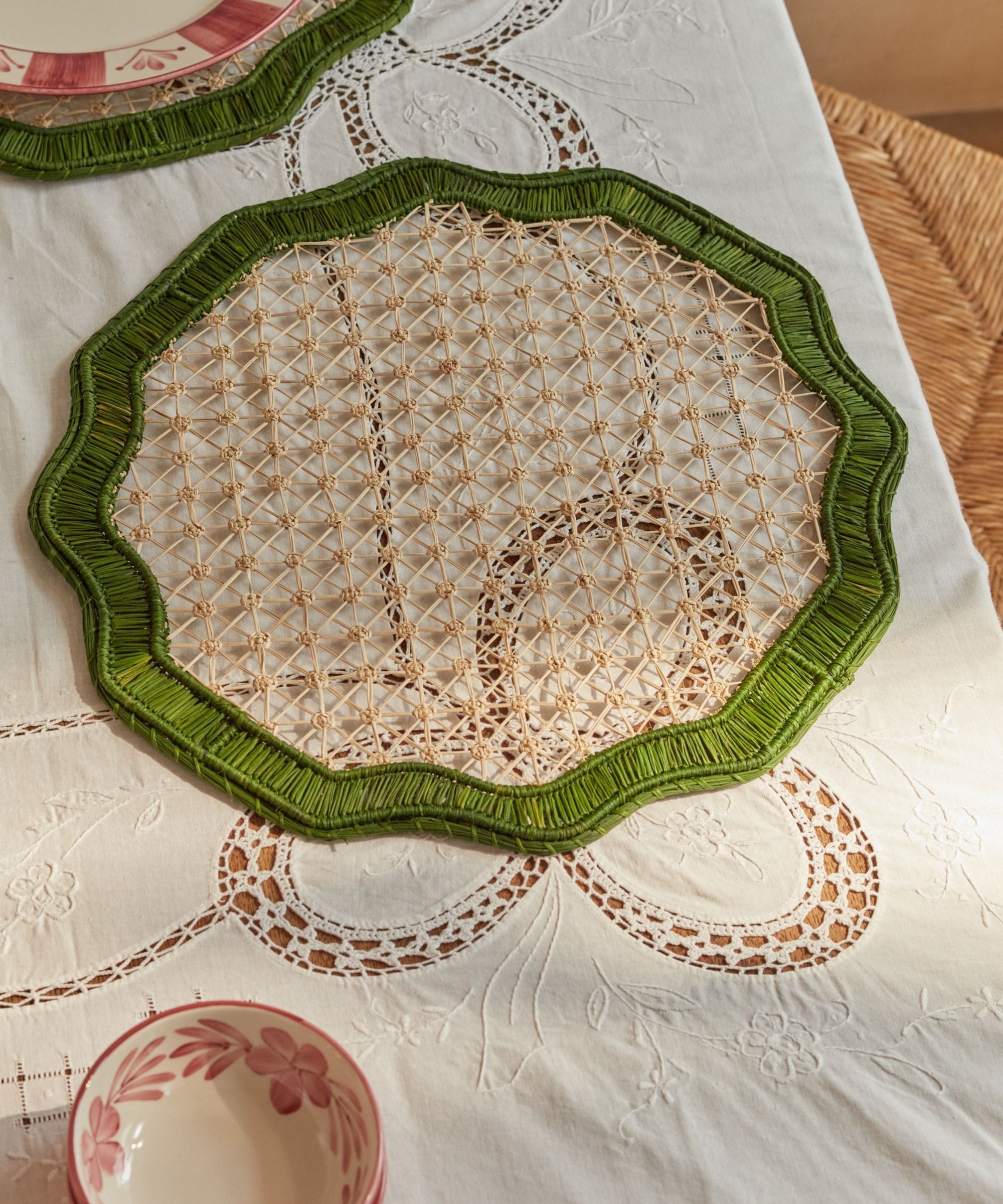 Deco geometric placemat in green, handwoven iraca palm, overhead view