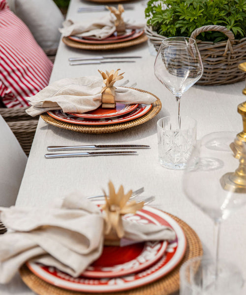 Dark Flor Side Plate in Rust Red, white floral on a deep ground — on a table setting