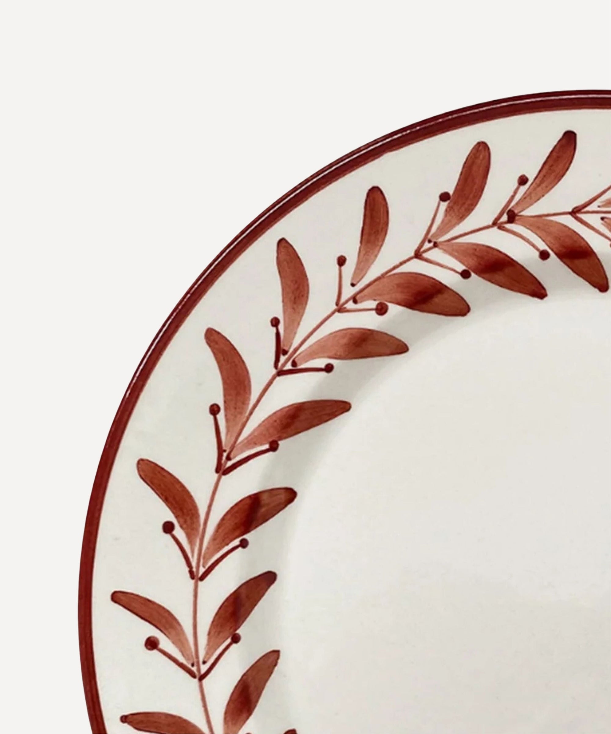 Helecho Side Plate Rust Red top-down view — fern wreath on white ground