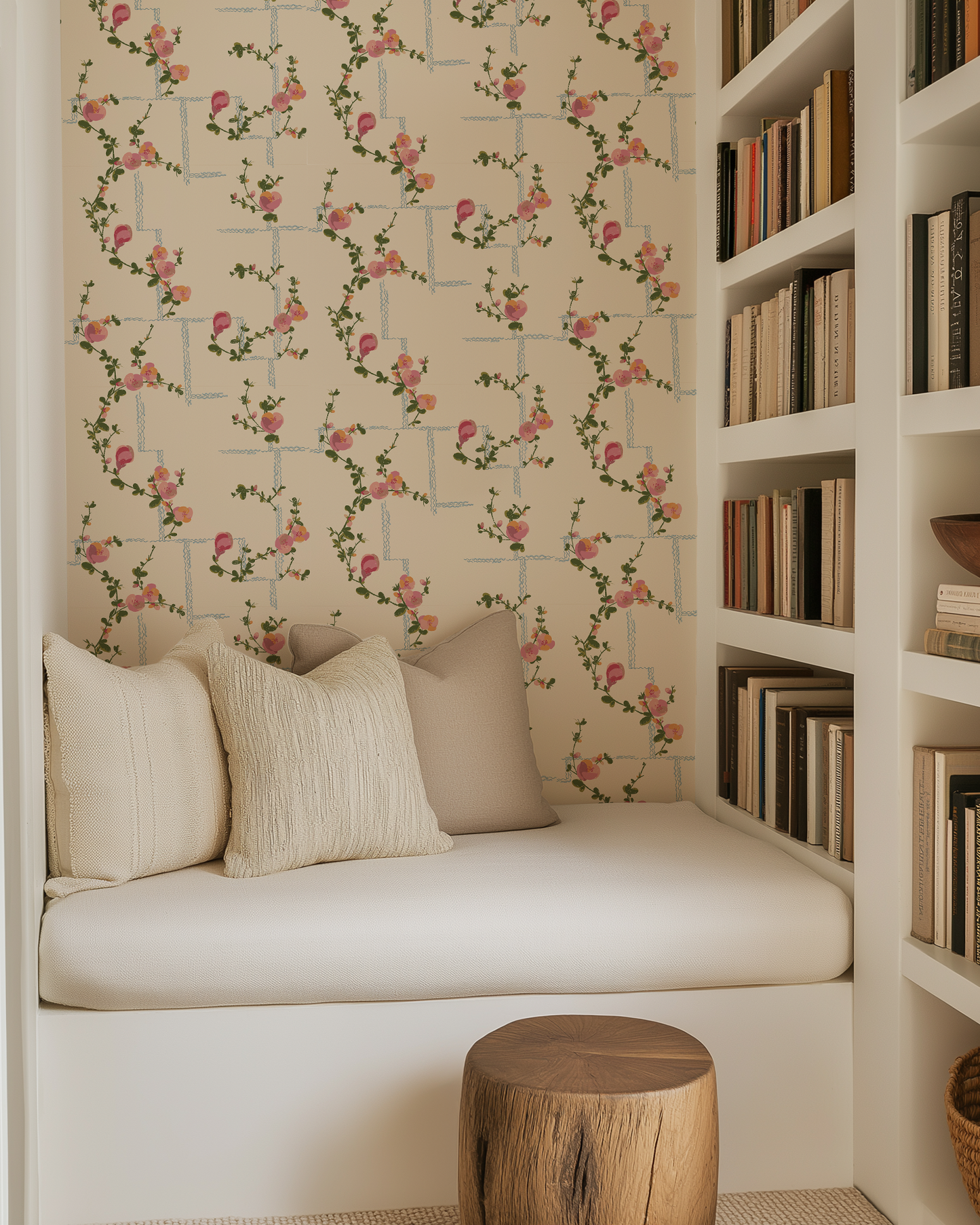 Cozy reading nook with floral wallpaper, cushioned bench, and bookshelf.
