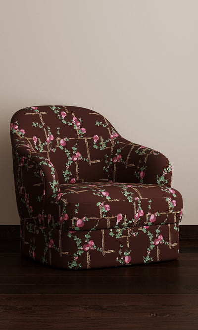 Dark floral-patterned armchair on a plain background.