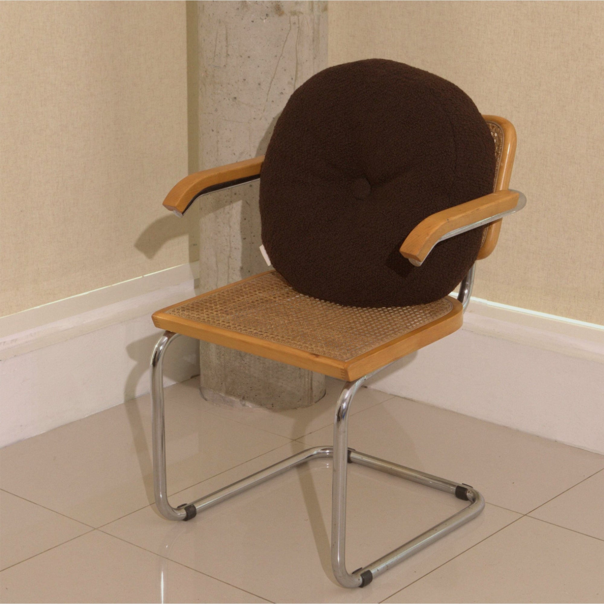 Brown wool bouclé round cushion on chair - handmade in UK