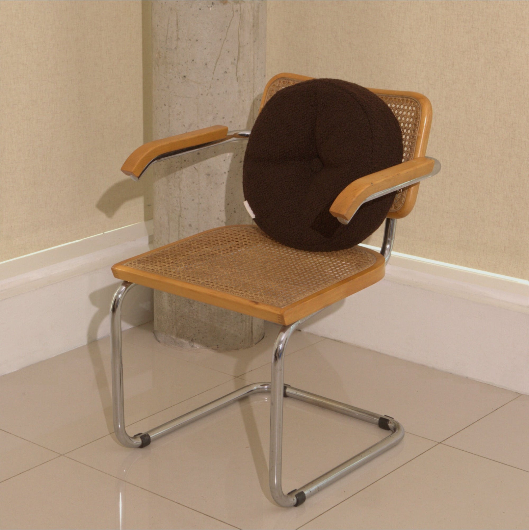 Brown wool bouclé round cushion on chair - handmade in UK