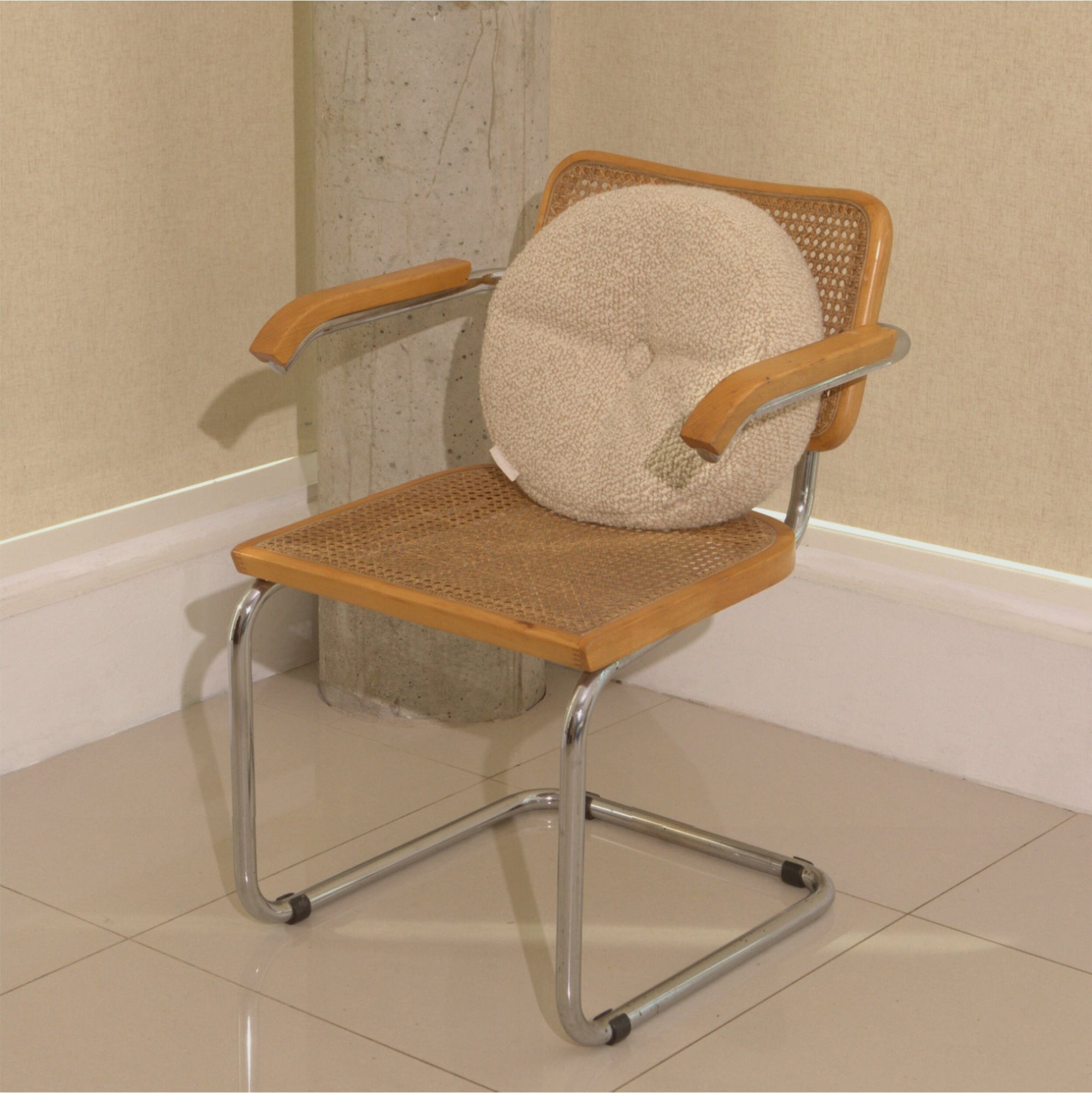 Cream wool bouclé round cushion on chair - handmade in UK