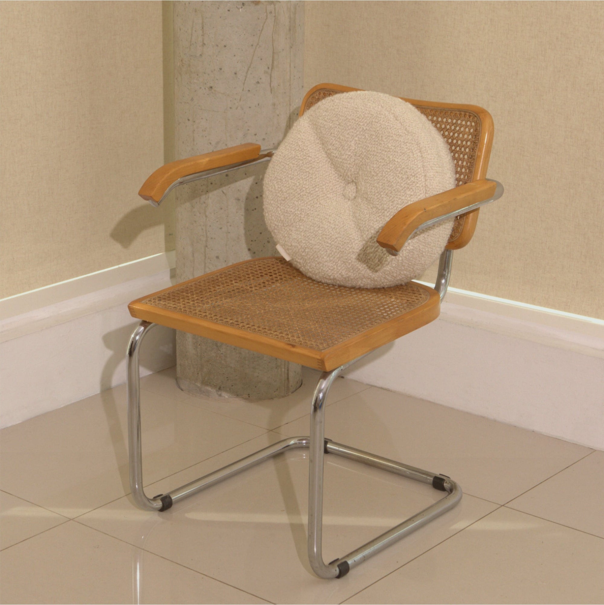 Cream wool bouclé round cushion on chair - handmade in UK