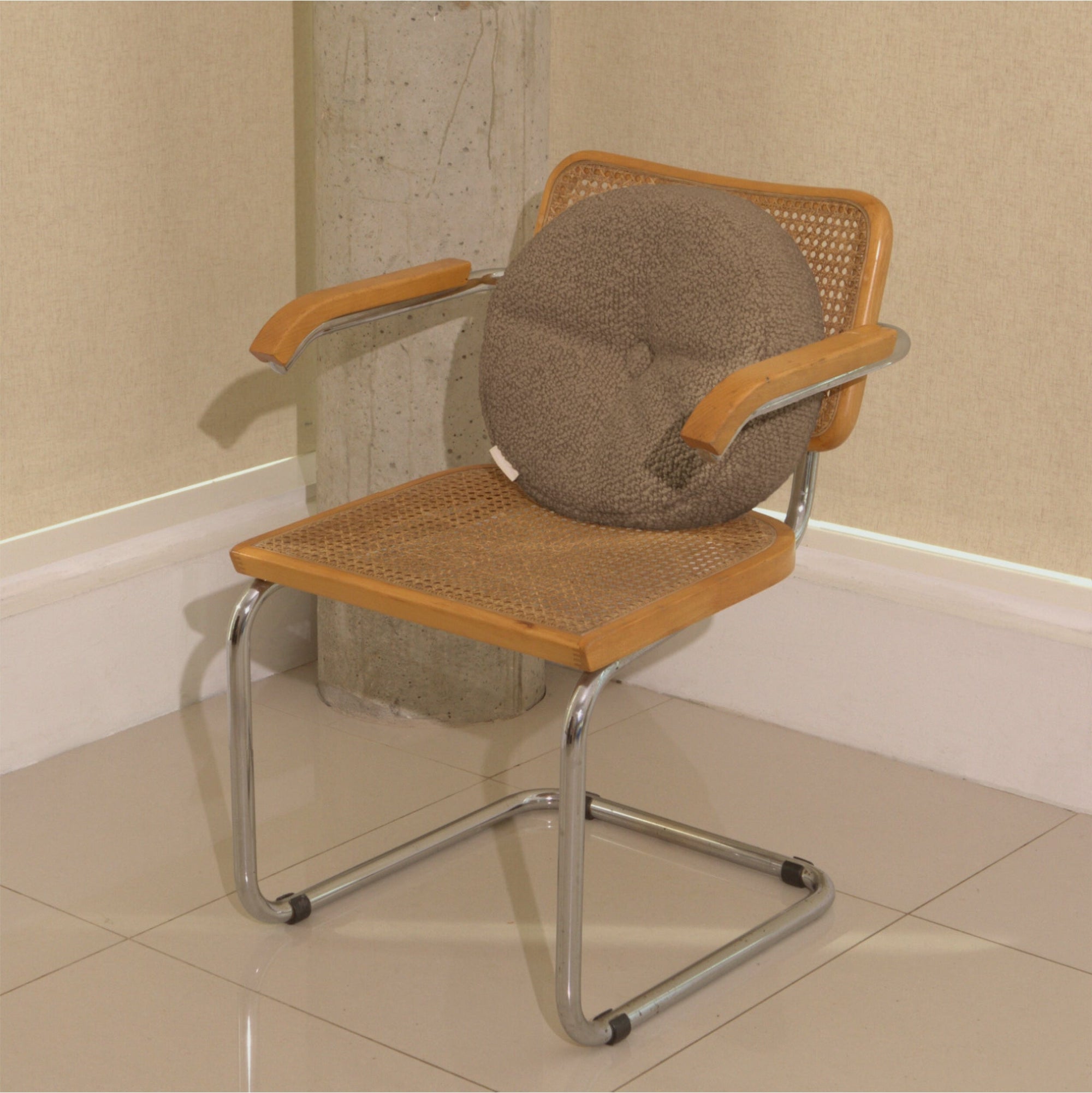 Beige wool bouclé round cushion on chair - handmade in UK