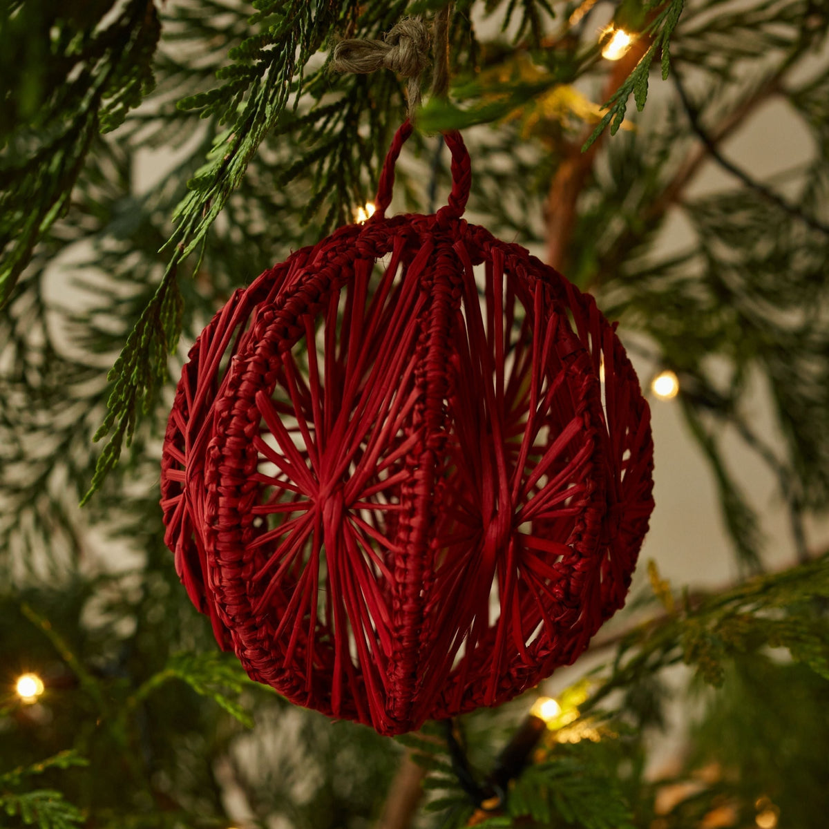Group of handwoven iraca palm Christmas baubles in red, green and natural