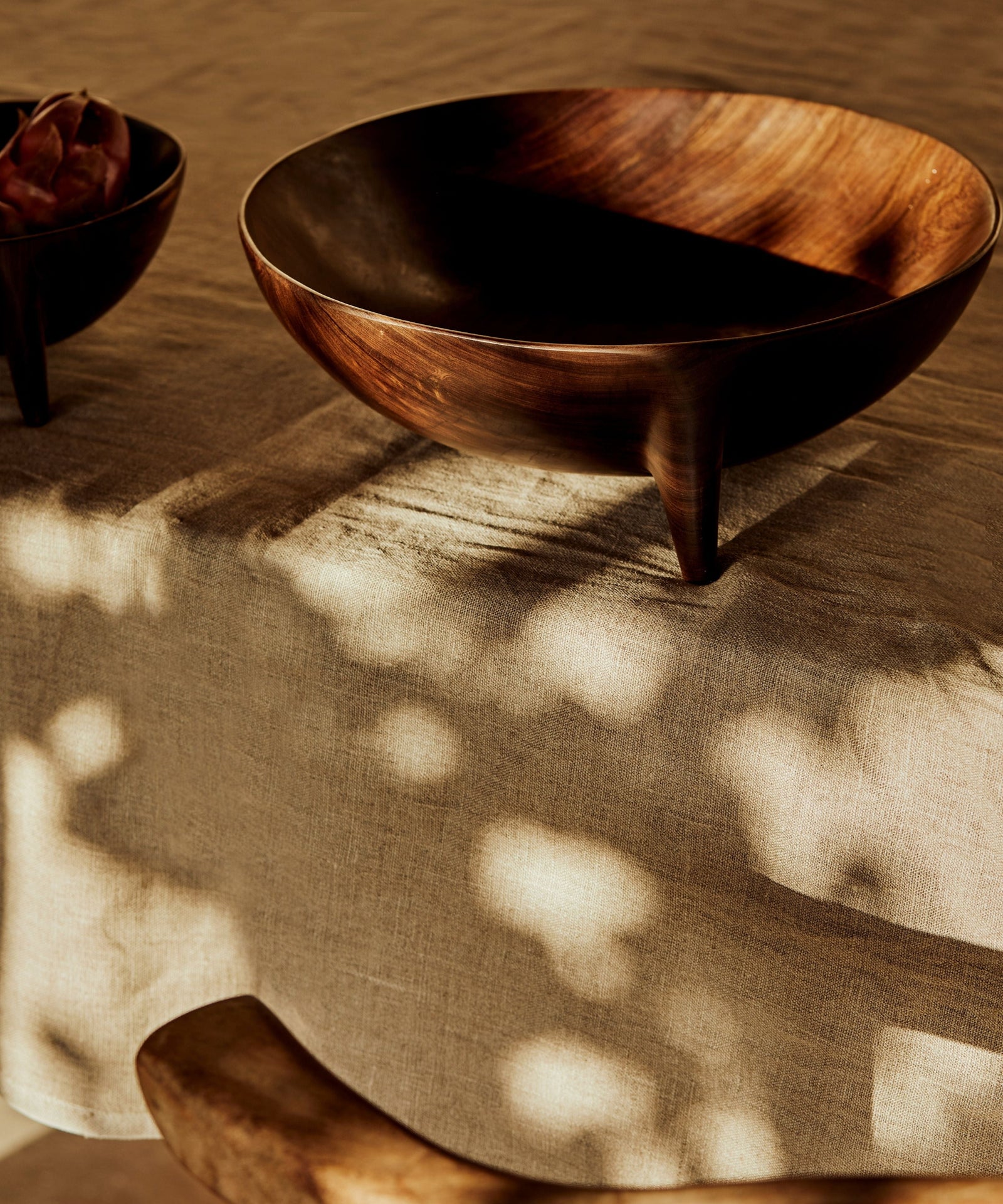 Hand-carved Lara wood bowl with raised three-leg silhouette
