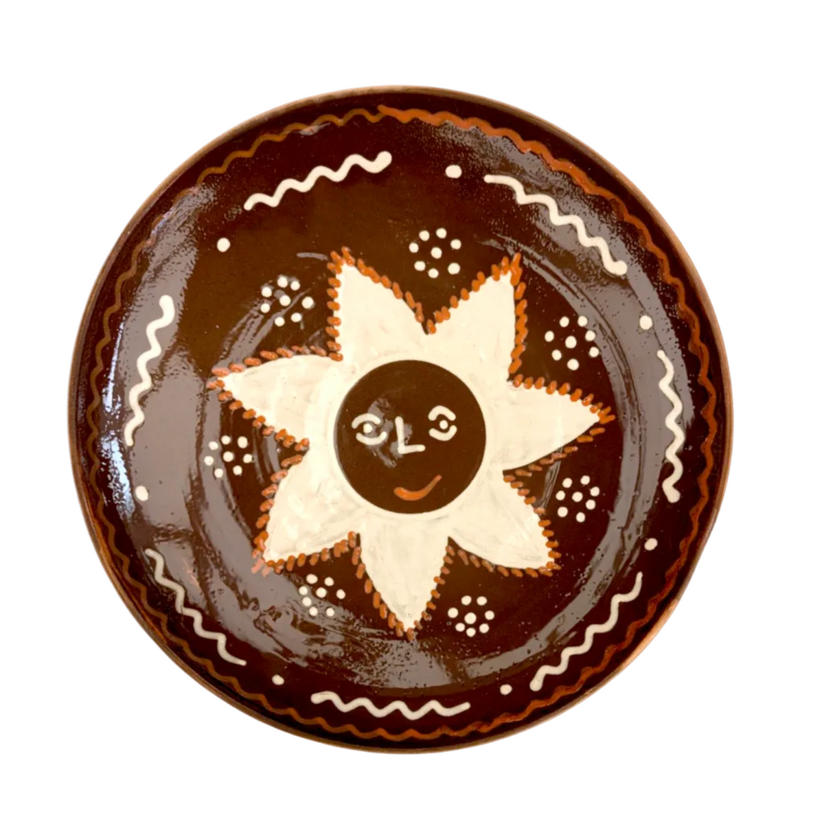 A large, handcrafted serving plate with a brown rim and a central white sun motif, decorated with traditional folk patterns.