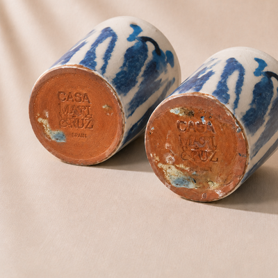 Two ceramic jars with blue and white patterns and 'Casa Mari Cruz' branding on a beige background.