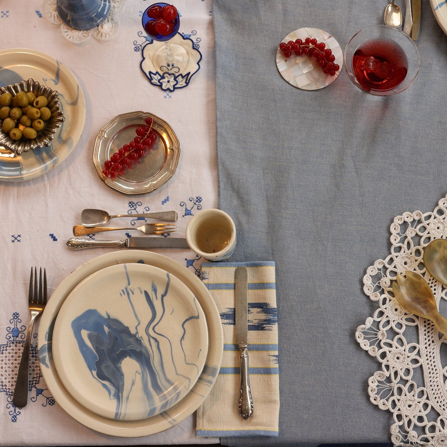 Elegant table setting with plates, cutlery, and glasses on a gray tablecloth. - lifestyle
