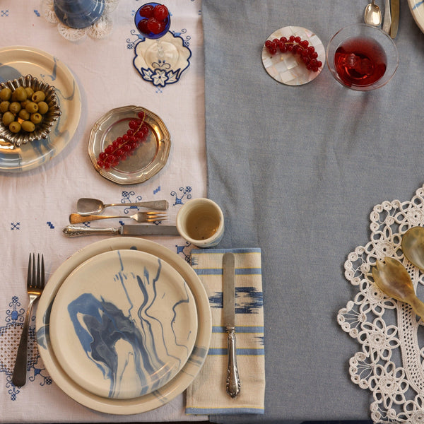 Elegant table setting with plates, cutlery, and glasses on a gray tablecloth. - lifestyle