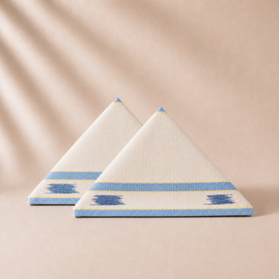 Two triangular napkins with blue and yellow patterns on a beige background