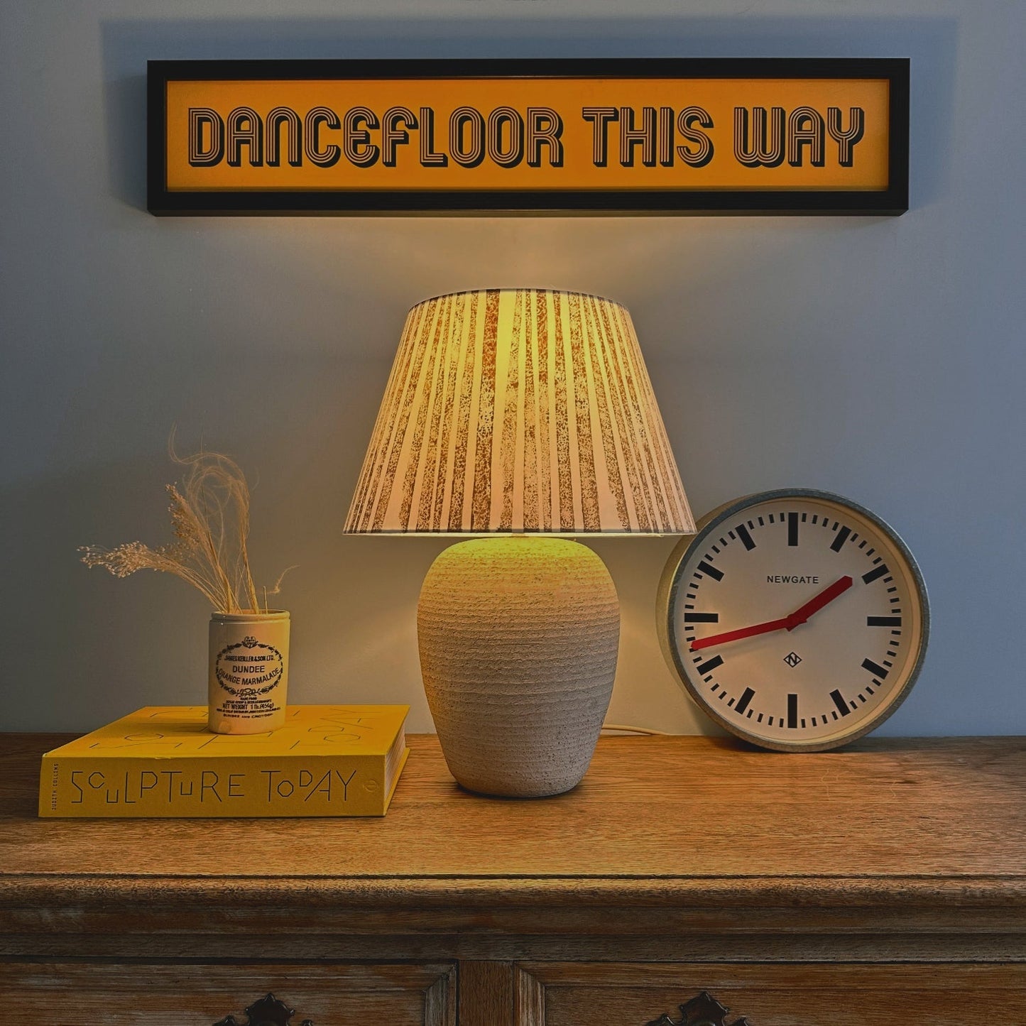Striped lampshade glowing warmly in evening light, creating bold striped lighting. A handmade empire lampshade that doubles as a bold lampshade statement piece.