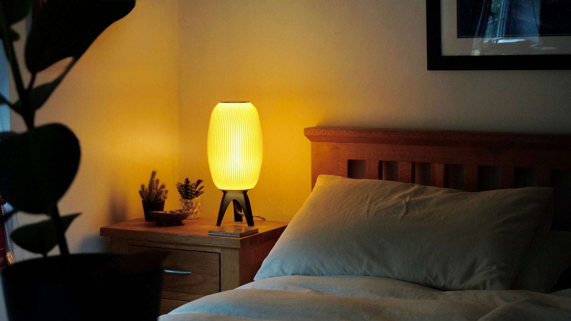 Bedroom scene with a lamp on a nightstand and a headboard.