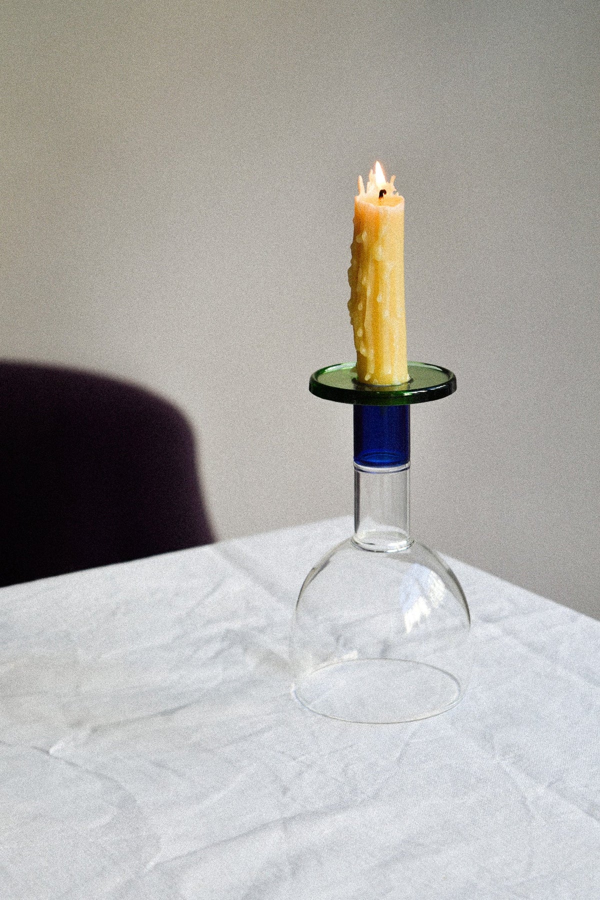 Wine candle glass with green and blue accents, featuring a candle on top and showcasing a taverna-style design.